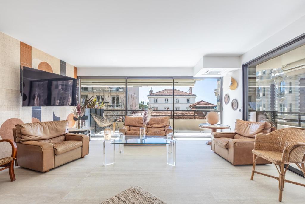 Elle comprend un salon meublé et une grande fenêtre. dans l'établissement LB Vacation Rentals I A short Stroll to Palais, Beach, Terrace & Seaview, à Cannes