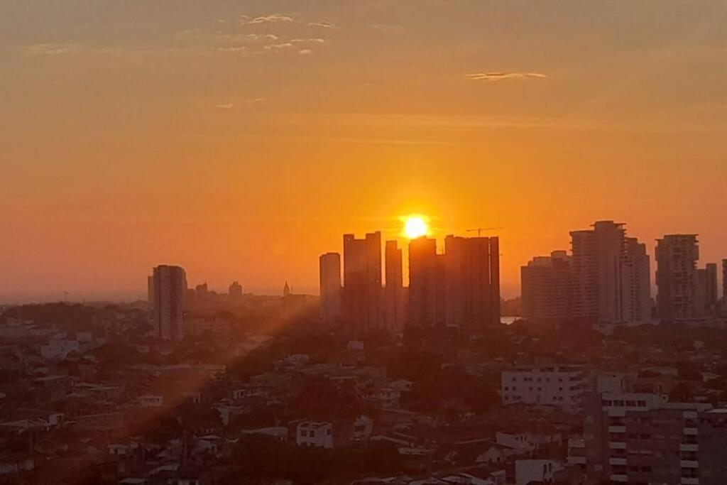 a city skyline with the sun setting in the sky at Confort y descanso cerca al mar in Cartagena de Indias