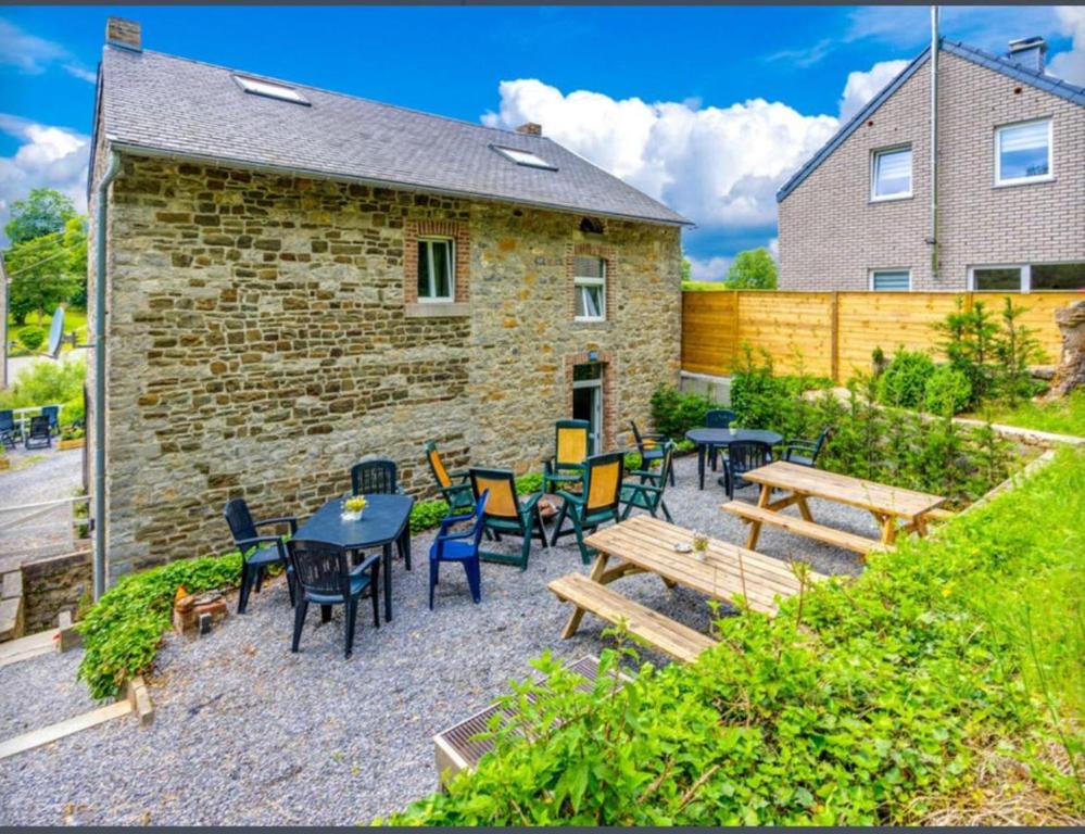 a patio with tables and chairs and a building at 6 bedrooms mansion with sauna enclosed garden and wifi at Aywaille in Aywaille