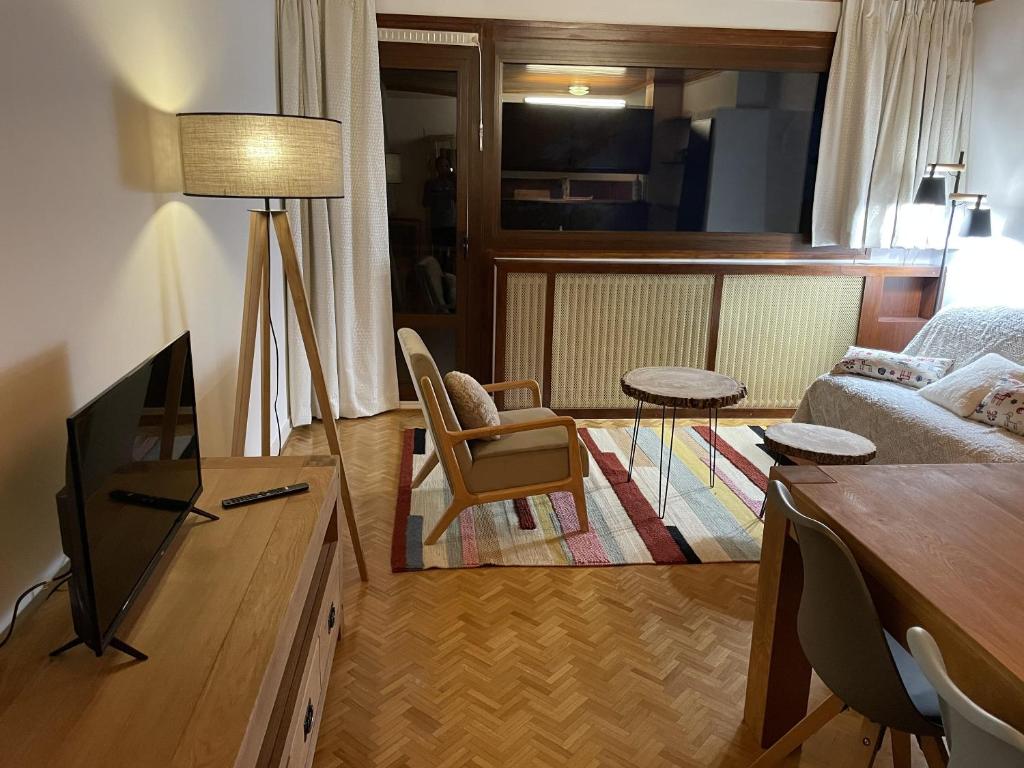 un salon avec un canapé et une télévision dans l'établissement Appartement chaleureux à Uvernet-Fours, 48m², vue montagne, à Uvernet