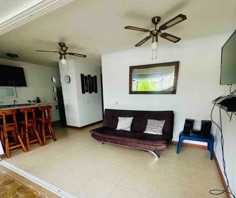 uma sala de estar com um sofá e uma ventoinha de tecto em Apartasol Santa Fe de Antioquia em Santa Fe de Antioquia