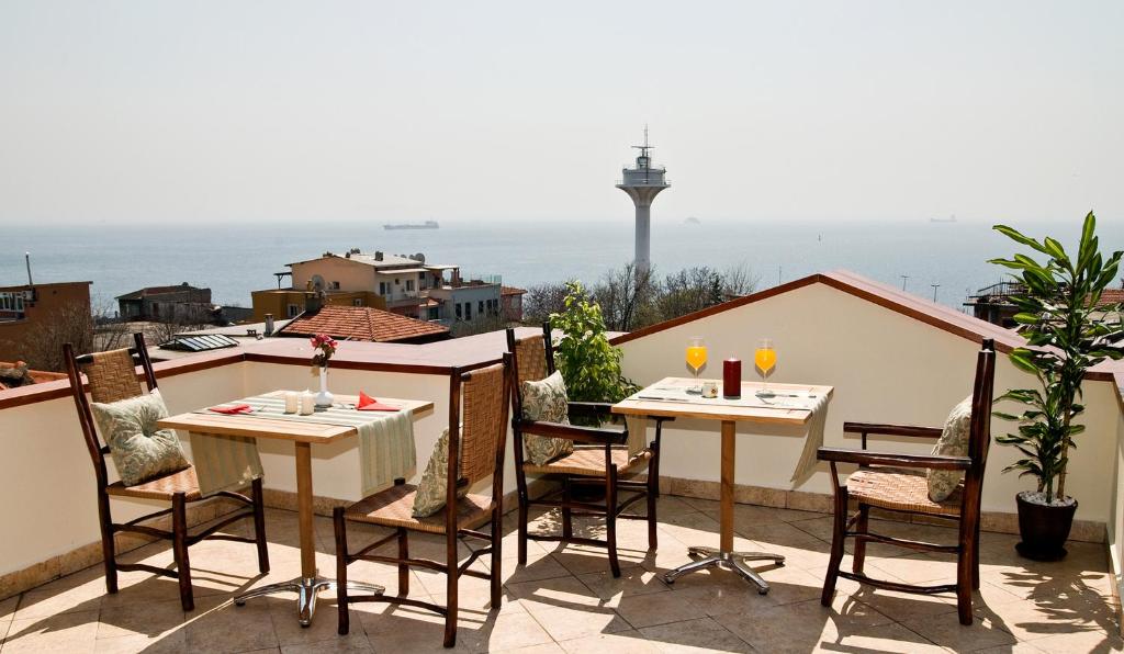 a dining room table with chairs and a balcony at Hotel Sphendon in Istanbul