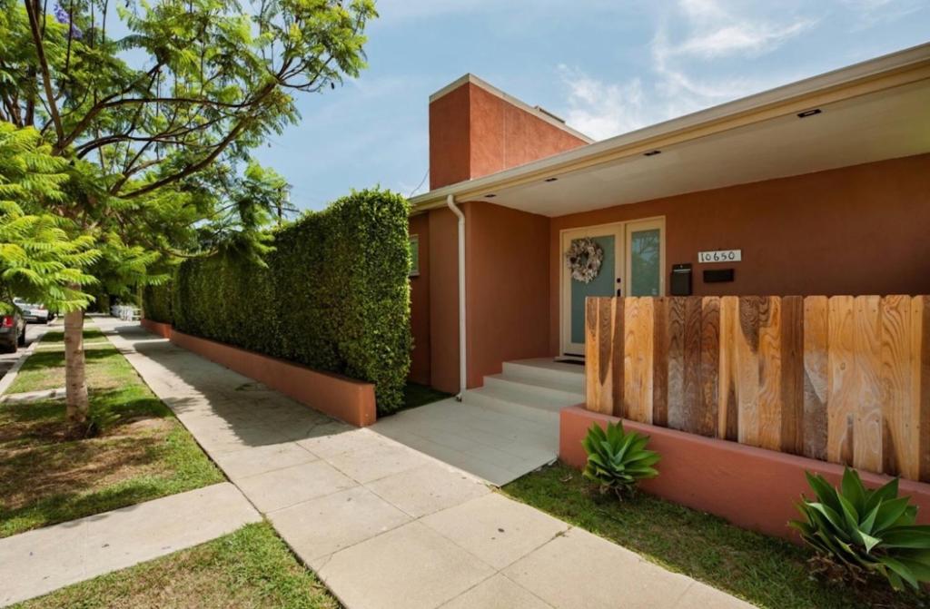 a house with a fence next to a sidewalk at Tranquility in Prime Location with Private Pool in Los Angeles