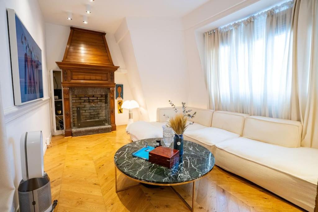 un salon avec un canapé blanc et une table dans l'établissement Luxueuse suite, à Paris