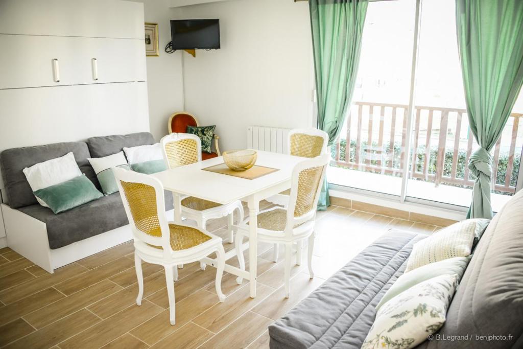 un salon avec une table, des chaises et un canapé dans l'établissement STUDIO COSY, à Cabourg