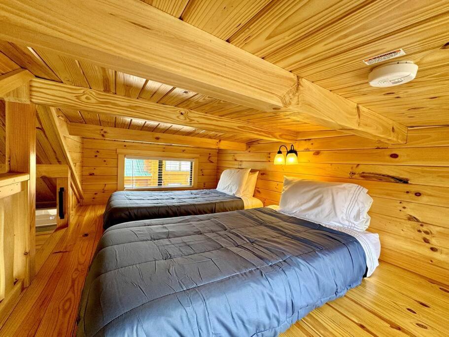 een slaapkamer met 2 bedden in een blokhut bij 2 Bedroom Log Cabin on Lake James with Loft- Private Resort Amenities in Marion