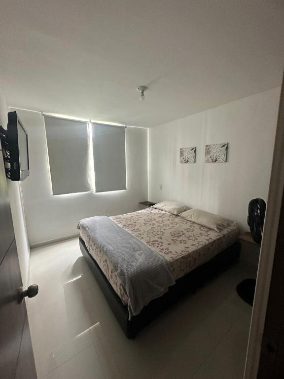 a bedroom with a bed and a tv in it at Hospedaje Los Cedros in Girón