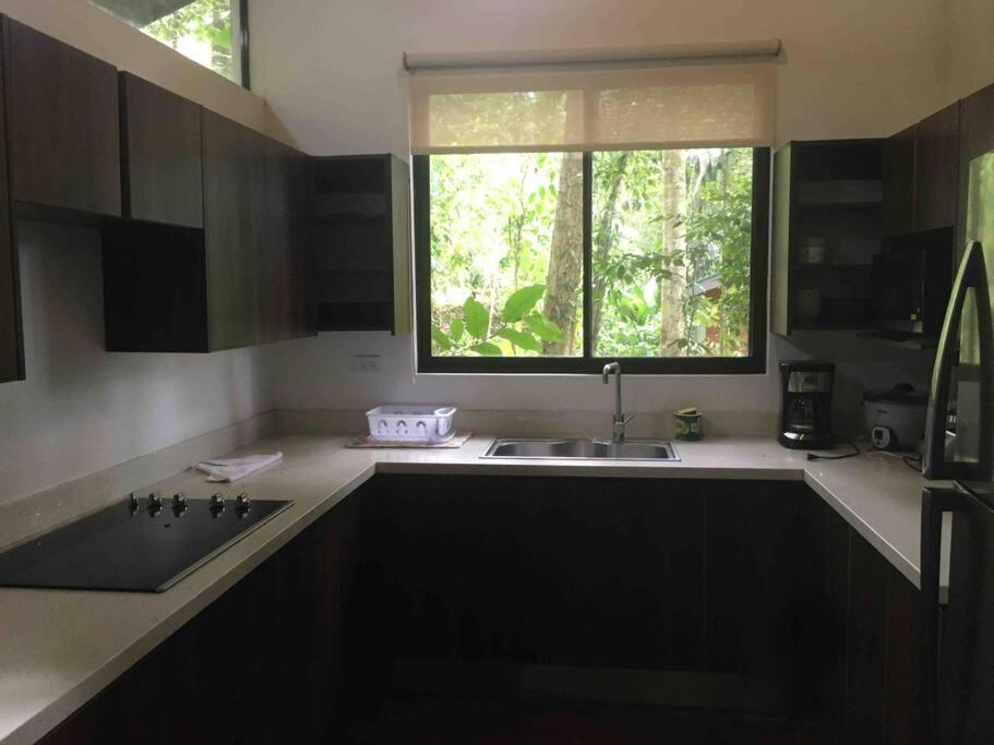 a kitchen with a sink and a window at Cabaña Bosquemar 1 in Agujas