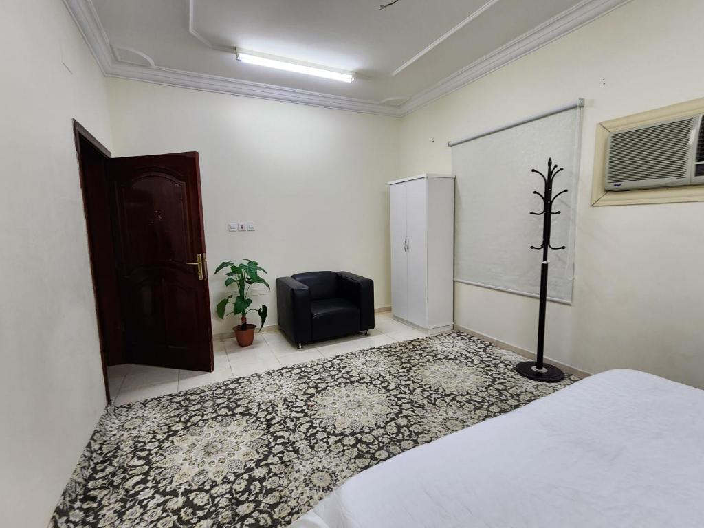 a room with a bed and a chair and a door at شقة طيبه المدينة 5 in Al Madinah