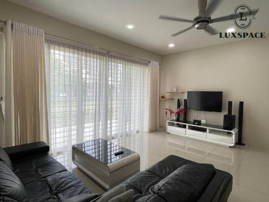 a living room with a couch and a flat screen tv at Cozy Kuching Samarahan Townhouse in Kota Samarahan