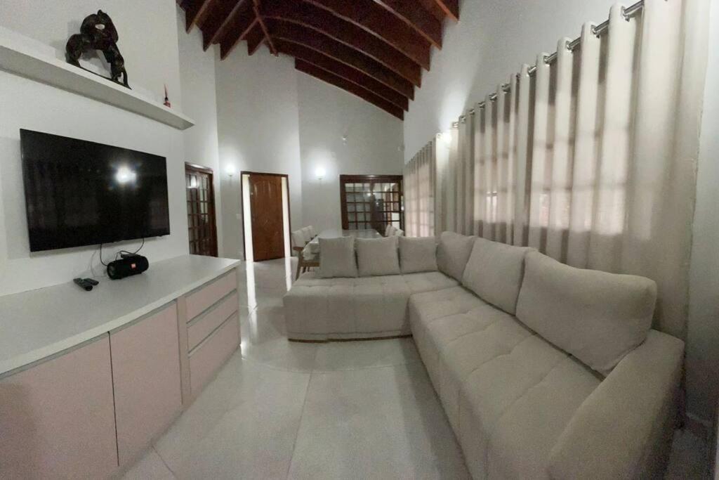 sala de estar con sofá blanco y TV de pantalla plana en Chacara casa de campo Condomínio fechado itupeva en Itupeva