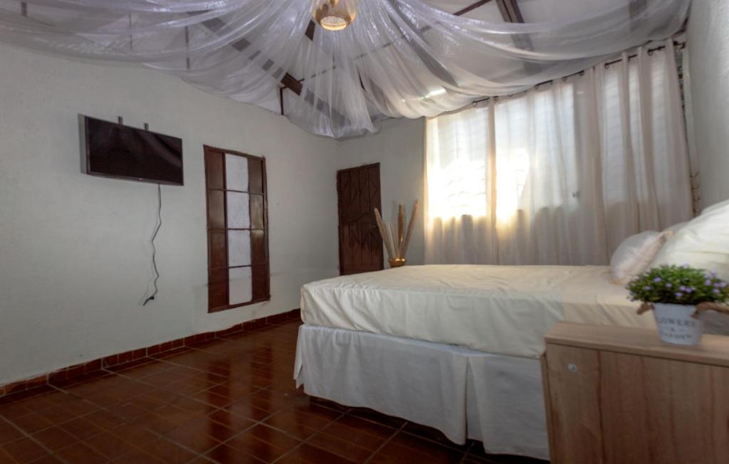 a bedroom with a bed with a white canopy at Hostal Lenha in Concepción de Ataco
