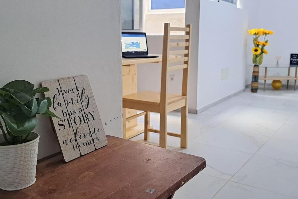 a wooden chair sitting next to a desk with a sign at Homestay In Maio - Room for Ladies, Couples & Families only, please in Calheta Do Maio