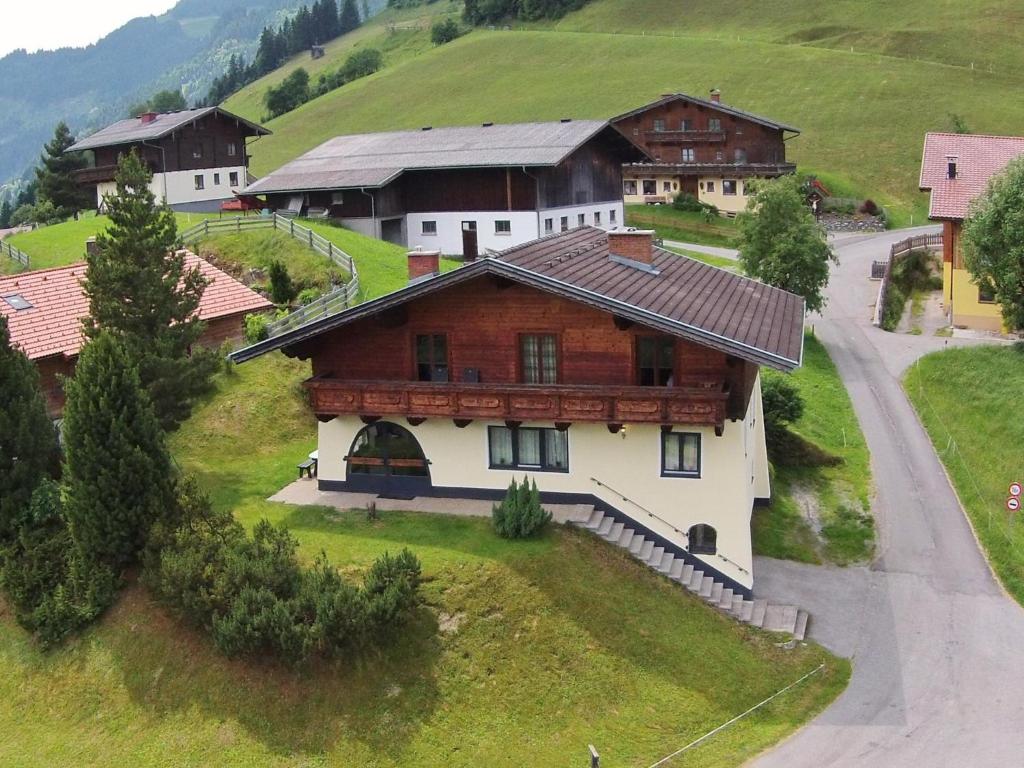 a large wooden house on a hill with a road at Chalet Kristall II in Grossarl