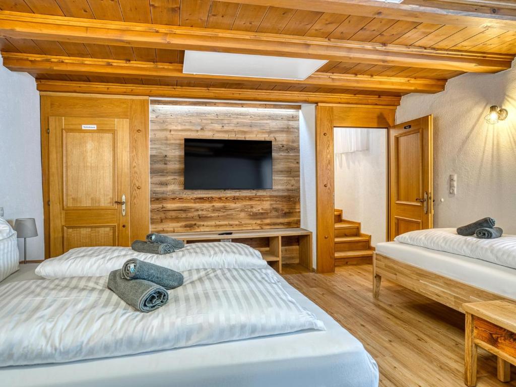two beds in a room with a television on a wall at Bergliebe in Kappl