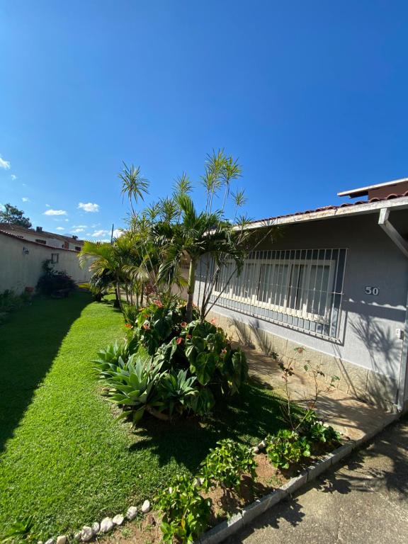 a side view of a house with a yard at Sua Casa na melhor localização de Teresópolis in Teresópolis