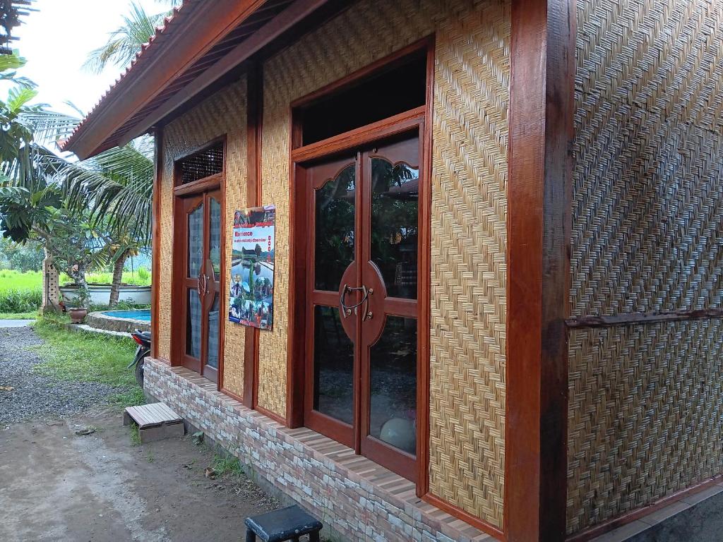 un edificio con puertas de madera en un lateral en LinkeesHome Bungaya, en Karangasem