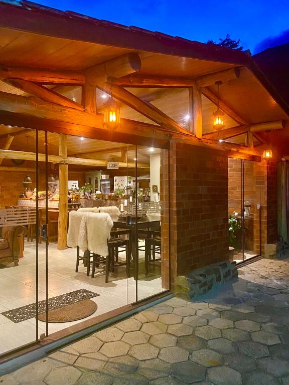a house with glass doors and a dining room at Pousada Altitude 1200 in Fazendinha