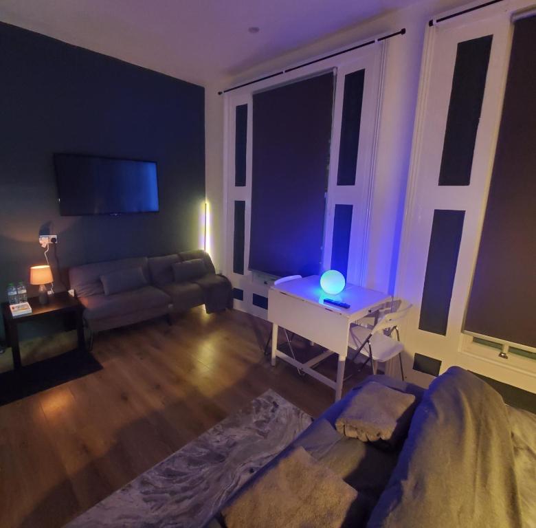 a living room with a couch and a table at London Oasis Studio Apartment in London