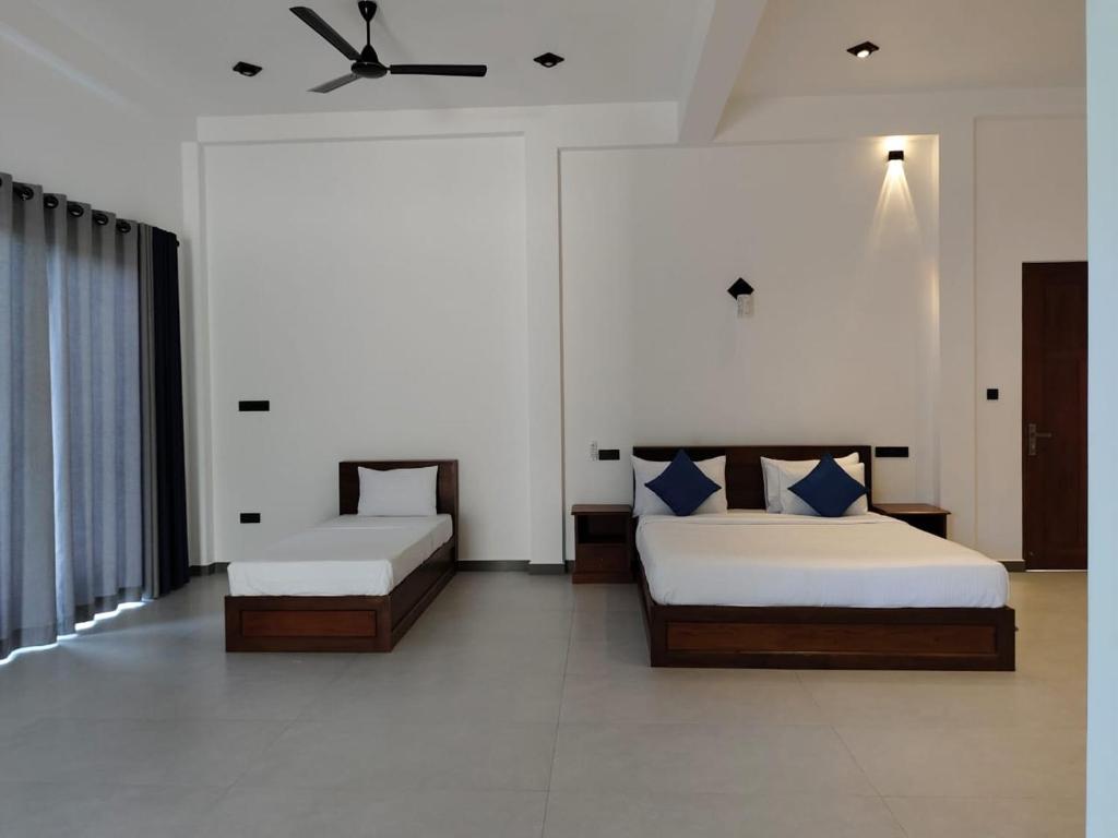 - une chambre avec 2 lits et un ventilateur de plafond dans l'établissement Villa Vyoma, à Talpe