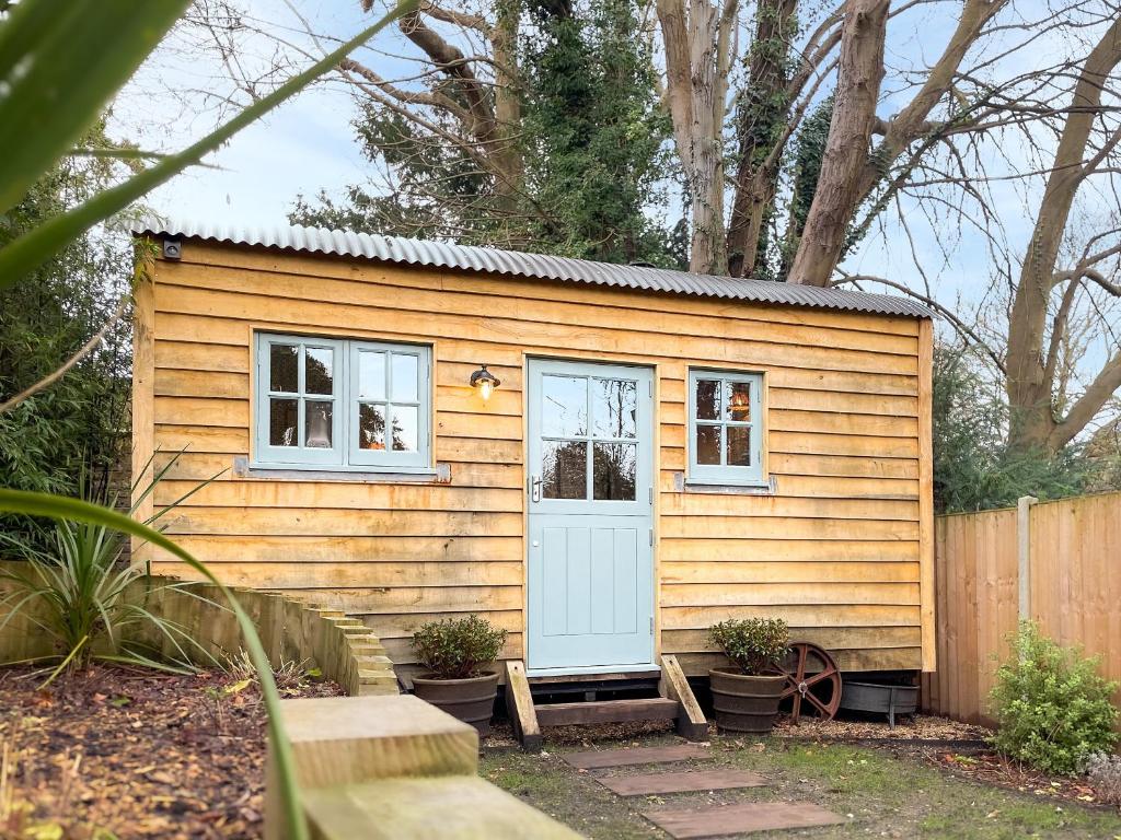a tiny house with a blue door and windows at The Granary in Steyning