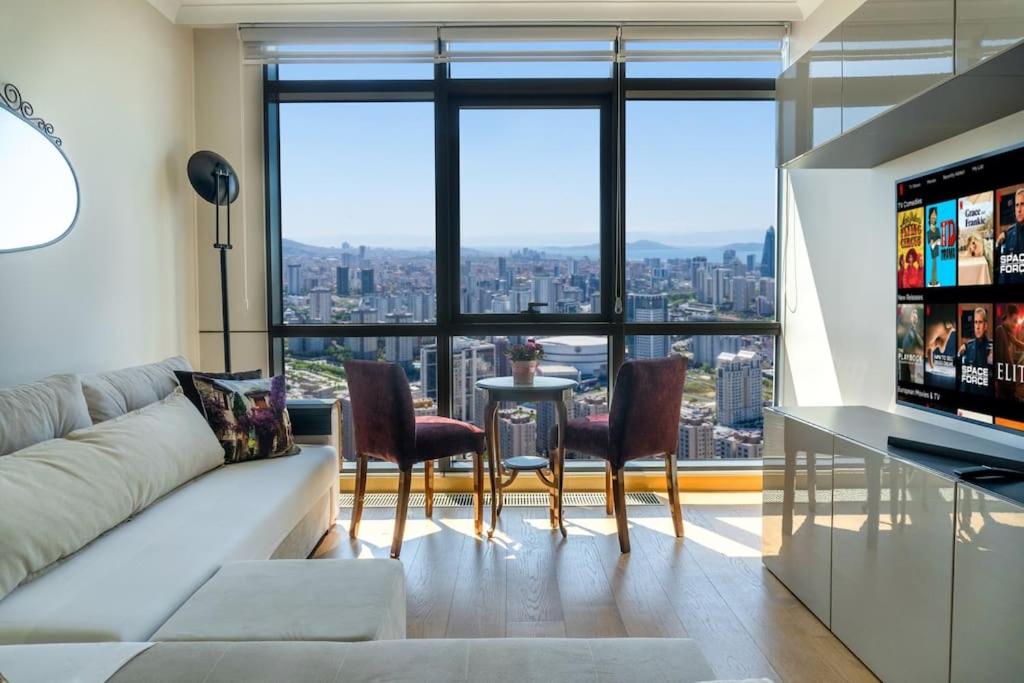 een woonkamer met een bank en stoelen en een groot raam bij Ataşehir's Most Luxurious Top Floor Residence in Istanbul