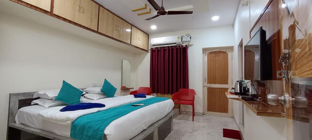 a bedroom with a large bed and a red chair at J Beach Stay Rooms in Visakhapatnam