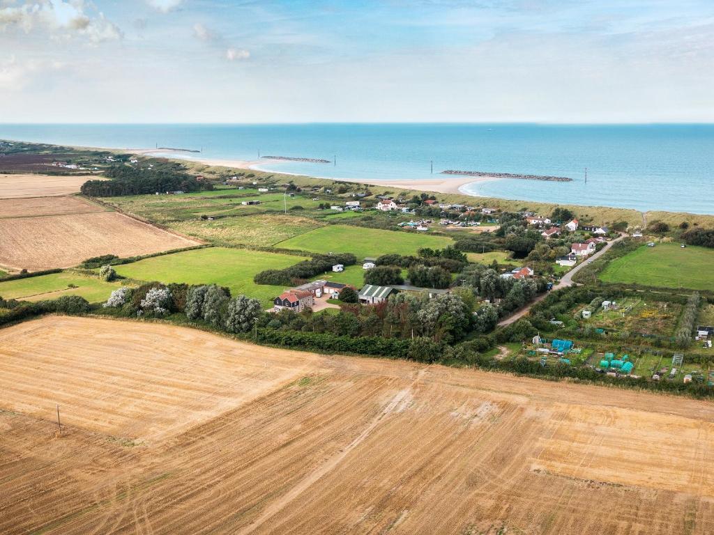 an aerial view of a farm next to the ocean at Hempstead End in Lessingham