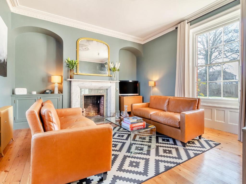 a living room with two chairs and a fireplace at Red House in Methwold