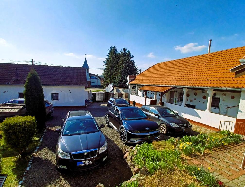 three cars parked in a parking lot in front of a house at Harmony Vendégház Egerszalók in Egerszalók