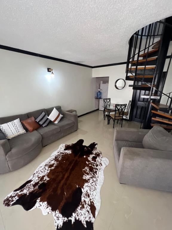een woonkamer met een bank en een tapijt op de vloer bij Ocho Rios Oasis in St Mary