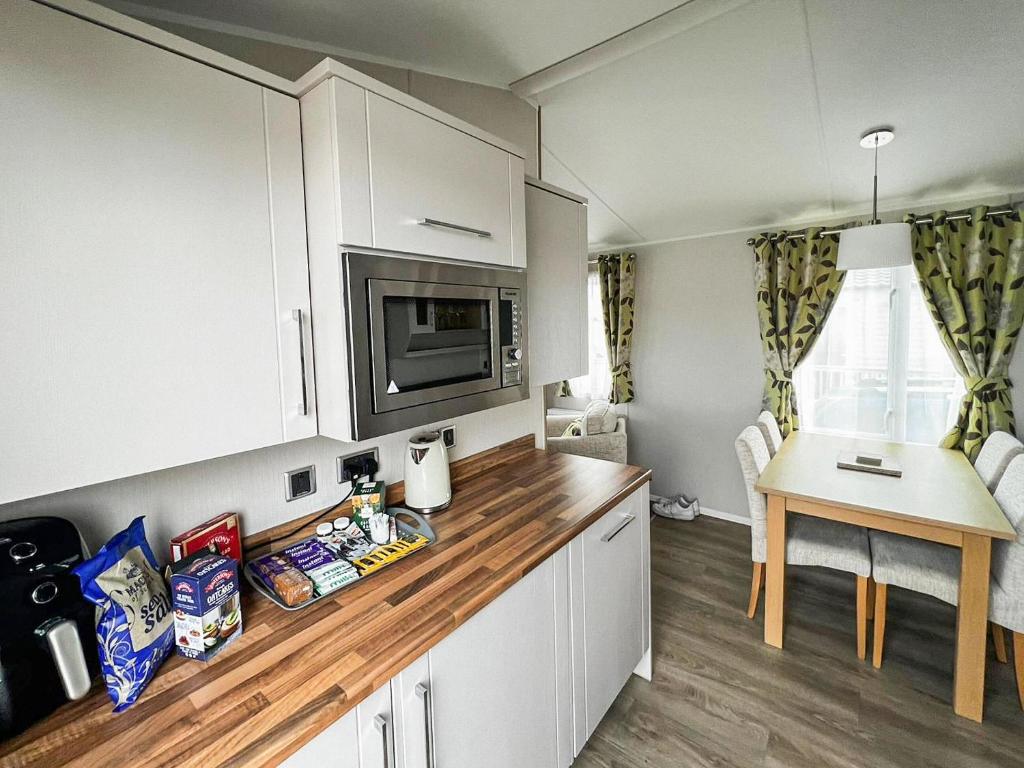a kitchen with white cabinets and a wooden counter top at Beeches View in Mainsriddle
