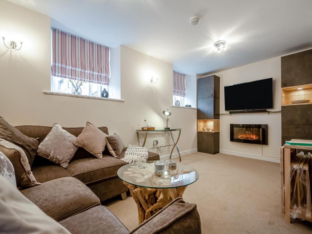 a living room with a couch and a fireplace at Mews Cottage in Abergele