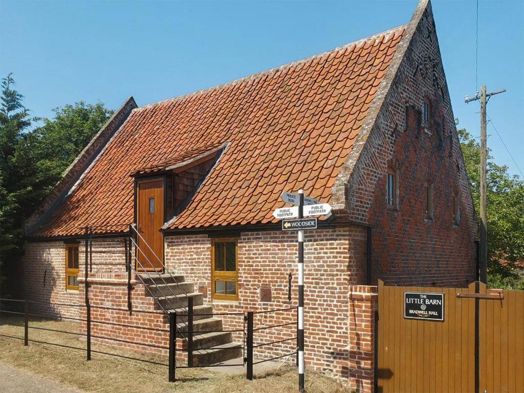 a small brick building with a brown roof at Little Barn At Bradwell Hall in Great Yarmouth