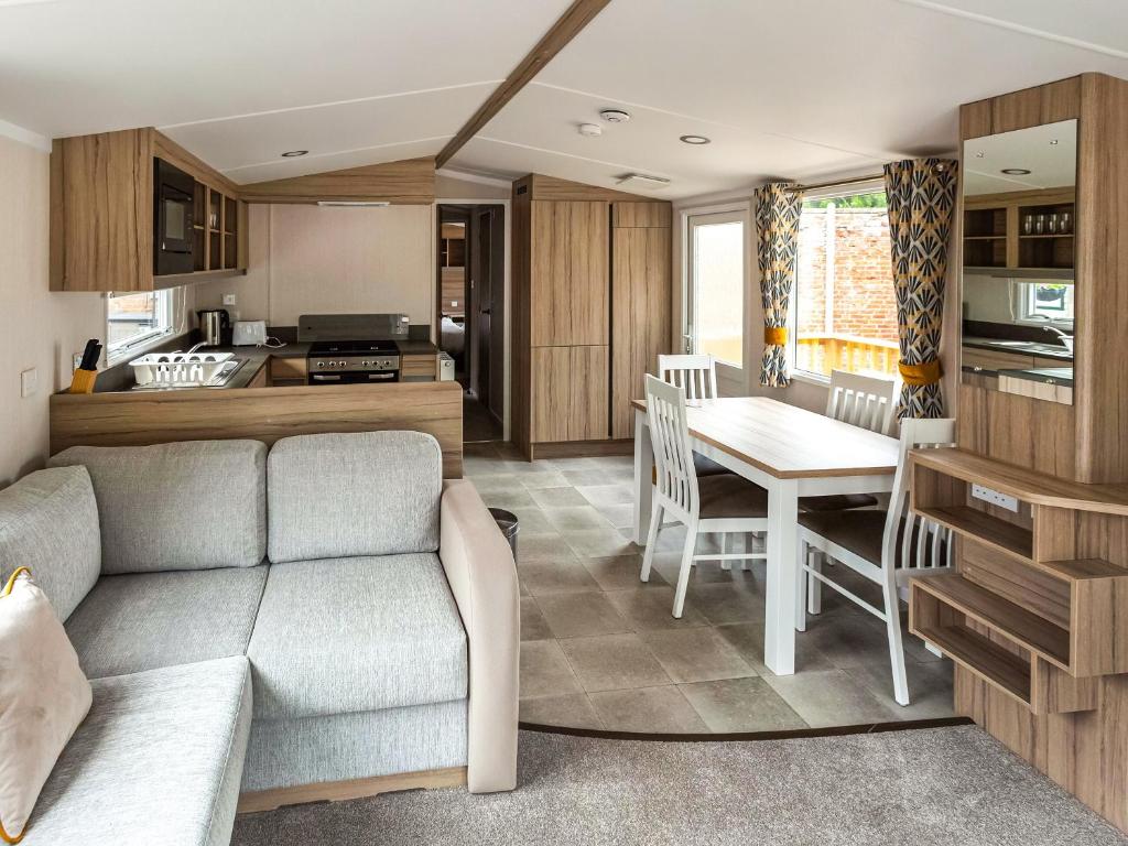 a living room and kitchen with a couch and a table at The Trout Van - Ukc6621 in Aberlour