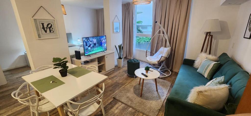 a living room with a green couch and a tv at Barrancas de Madero in Buenos Aires