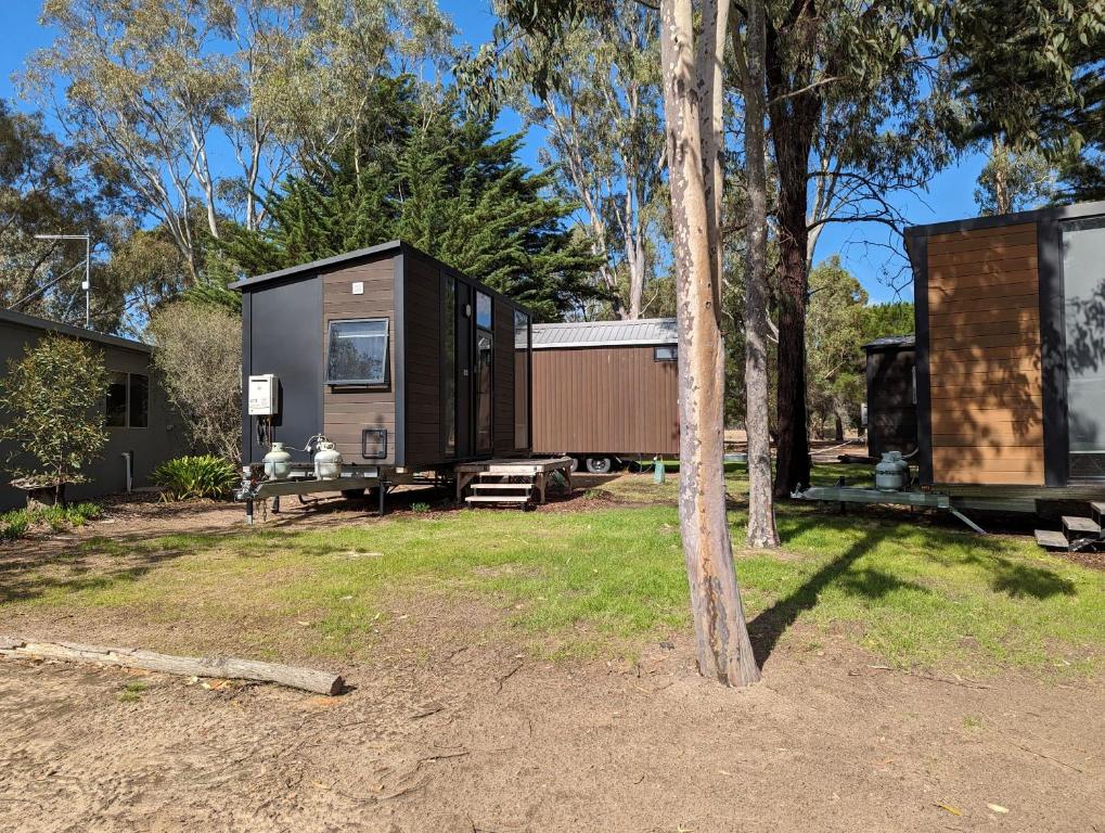 a black tiny house sitting on top of a yard at Tiny House 14B at Grampians Edge in Dadswells Bridge