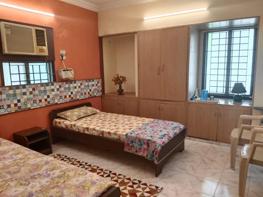 1 dormitorio con 2 camas y espejo en WISHTREE DORMITORY/CORPORATE DORMITORY FOR TECHIES AND TRAINEES, en Chennai