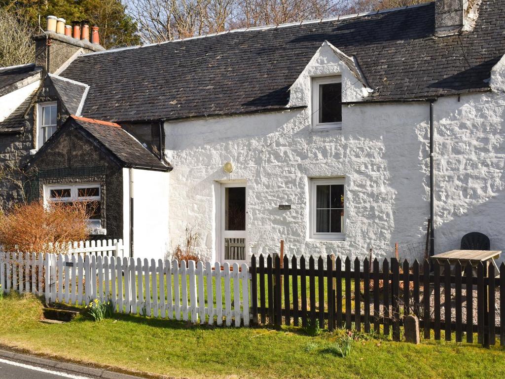 a white house with a white picket fence at Bayview in Kentallen