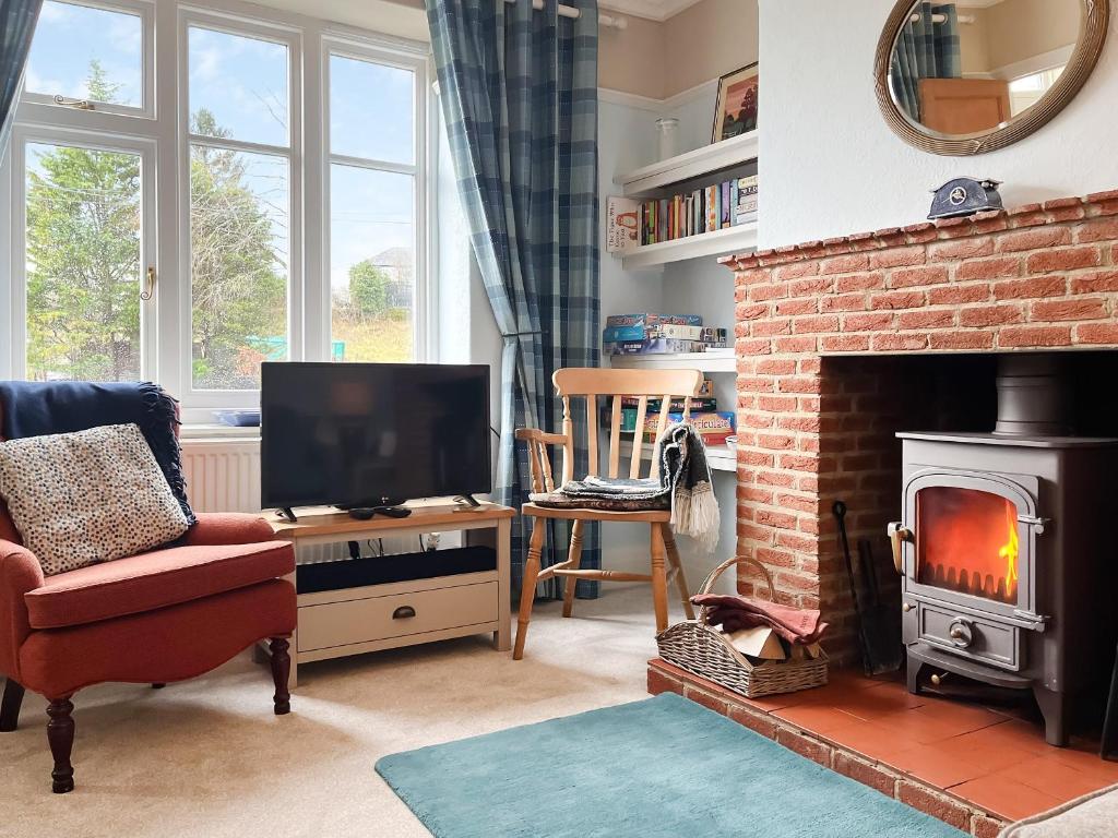 a living room with a television and a fireplace at River View in Youlgreave