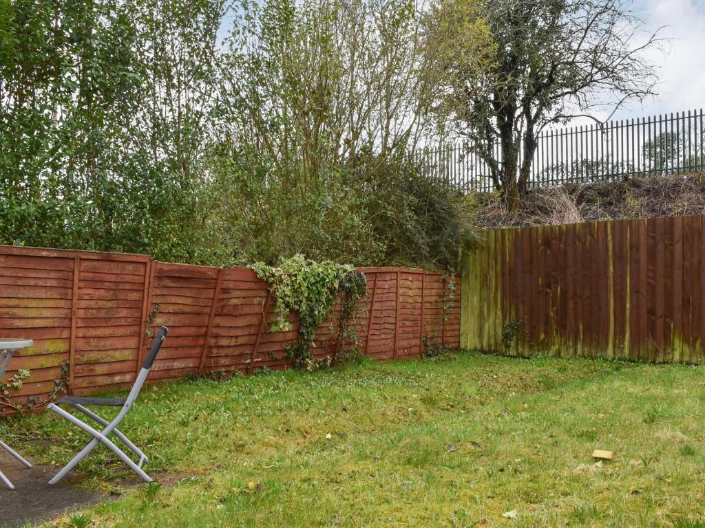 a chair sitting in a yard next to a fence at Wyndham House in Troed-y-rhiw