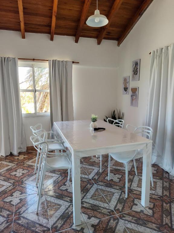 a dining room with a white table and chairs at Apartamentos Mara - 100m de Termas in Federación