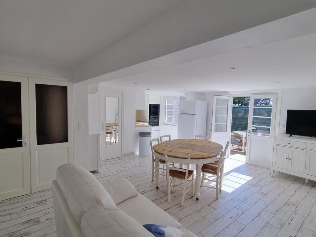 Appartement Vieux-Boucau-les-Bains, 5 pièces, 8 personnes - FR-1-239-761 في فيو بوكو لي بان: غرفة معيشة بيضاء مع طاولة ومطبخ