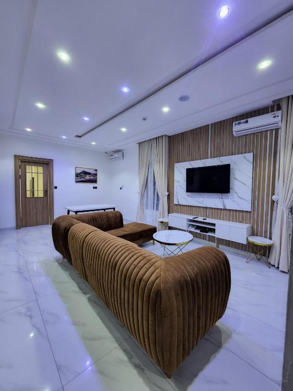 a large living room with a couch and a tv at Samuel Court in Abuja