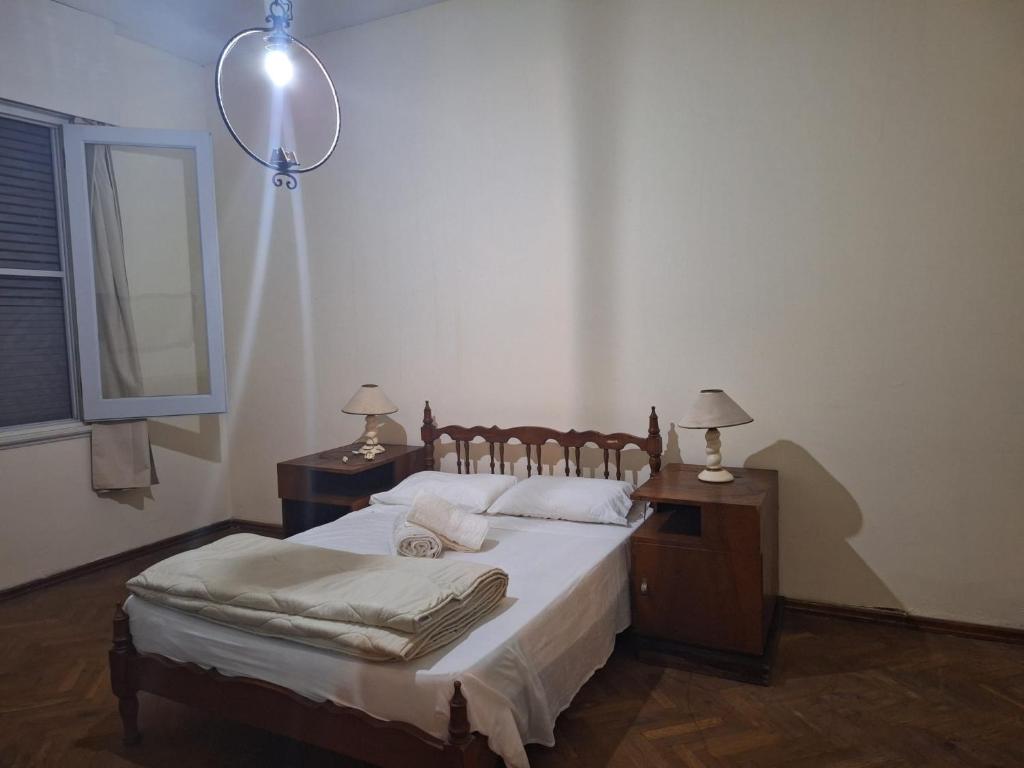 een slaapkamer met een bed met een spiegel en 2 lampen bij Casona Harguindeguy in Paysandú