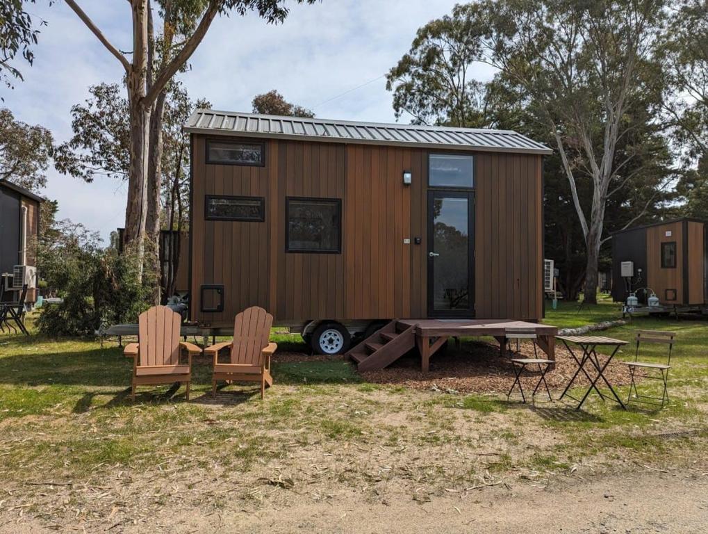 a tiny house with a picnic table and chairs at Tiny House 11 at Grampians Edge in Dadswells Bridge