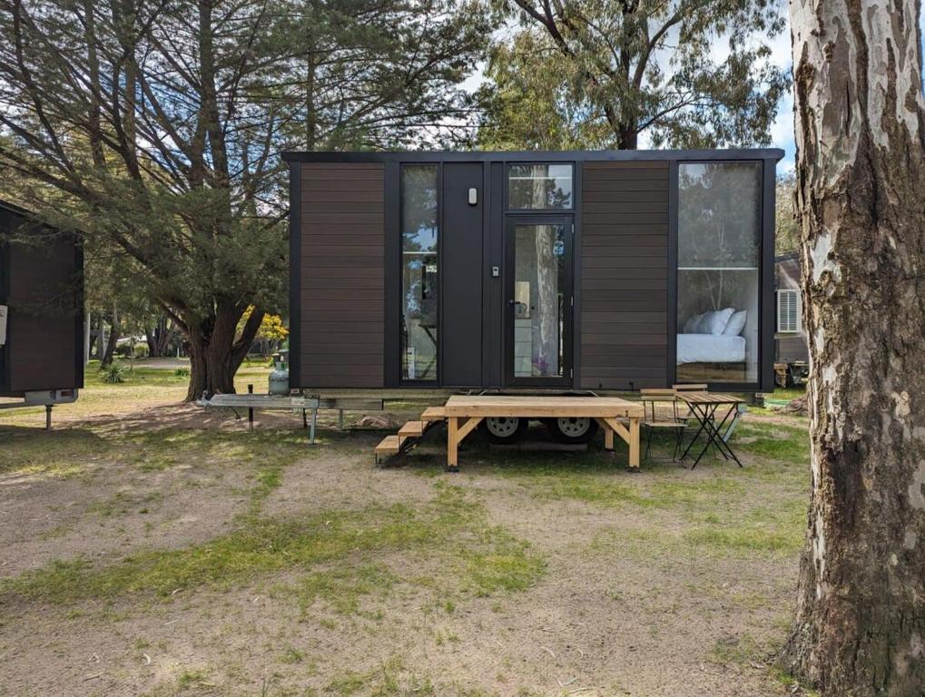 a tiny house with a picnic table and a bench at Tiny House 15 at Grampians Edge in Dadswells Bridge