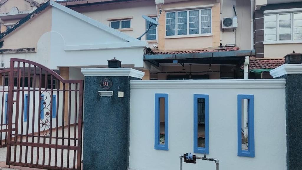 a white house with a gate and a fence at Eing's Homestay - Muslim And Mahram Only in Kajang