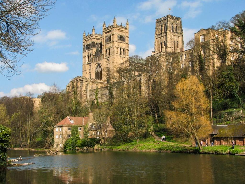 a castle with two towers and a lake in front of it at Hobbit Hollow - Uk45980 in Ebchester