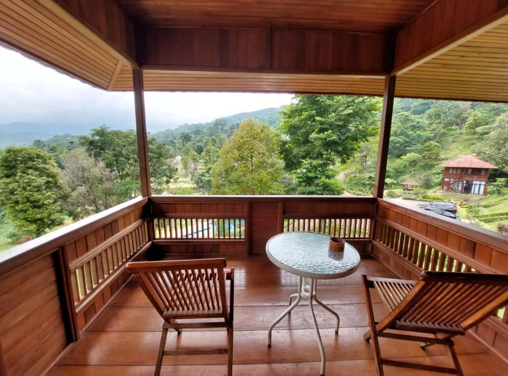 Un balcón con mesa y sillas y una vista en Gunung Geulis Camp Area, en Pasirkuda